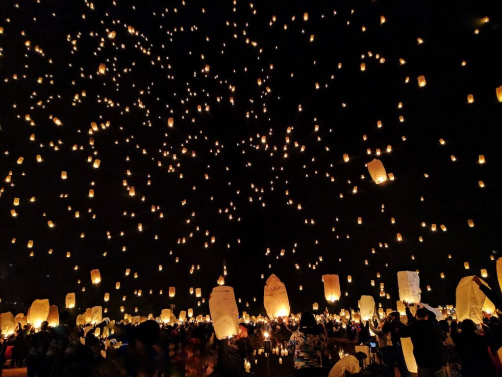 Group of People Throwing Paper Lantern on Sky during Night